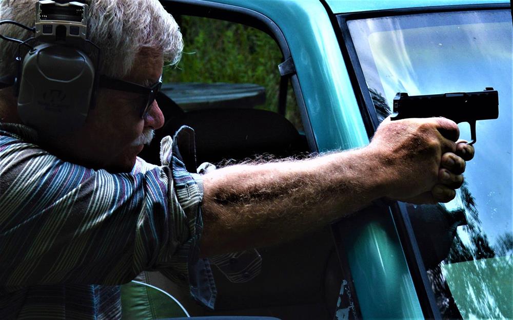 Firing the Beretta APX Carry pistol over the windshield of a pickup truck