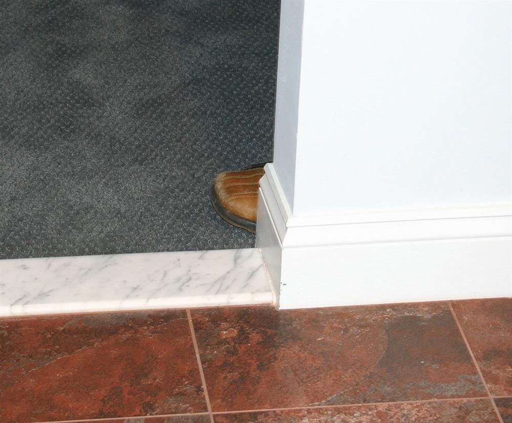 doorway showing a the toe of a shoe exposing a person who is hiding