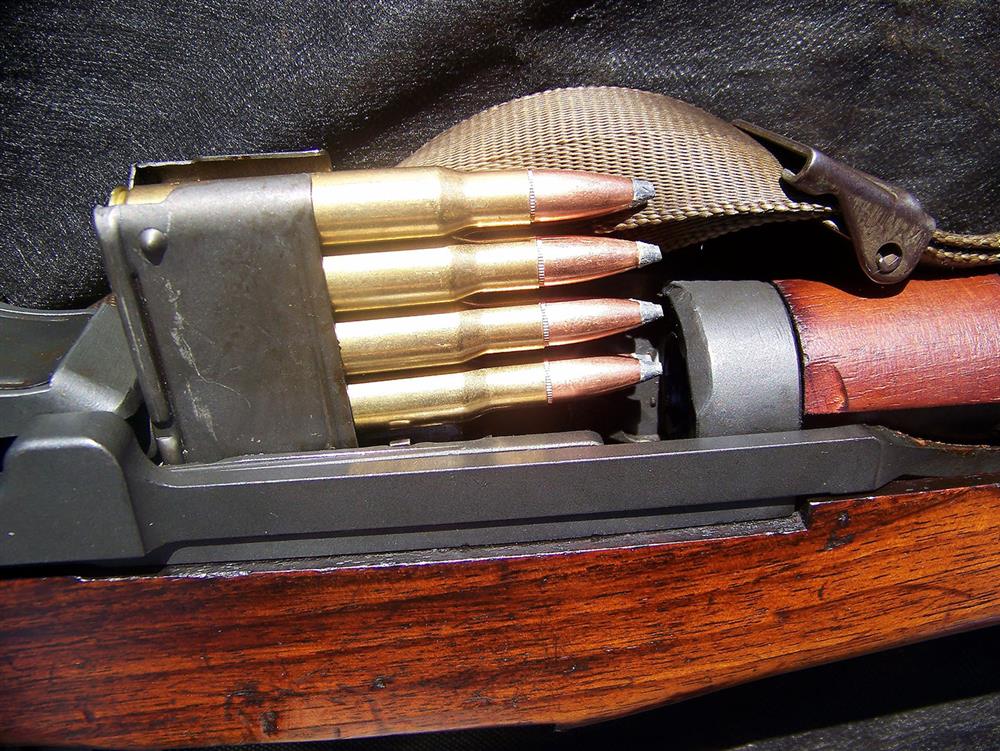 an en bloc clip being loaded into an M1 Garand rifle