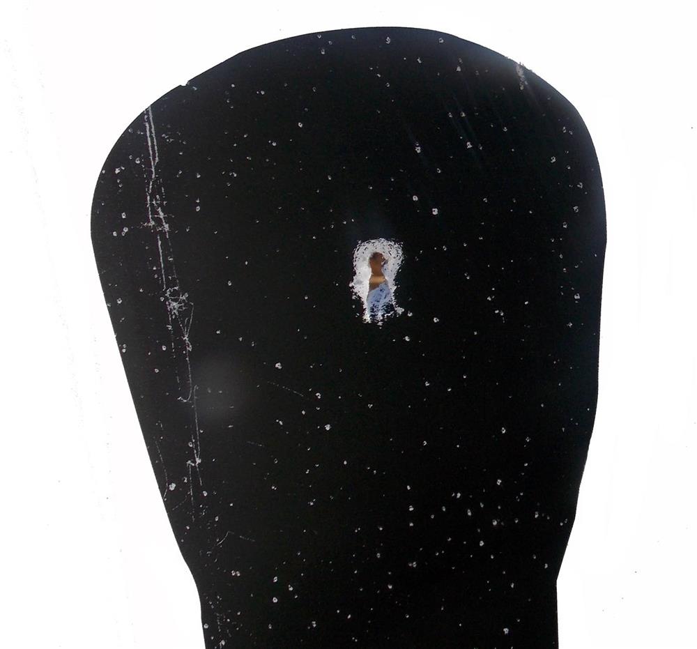 Single bullet hole in the center of a silhouette target's head