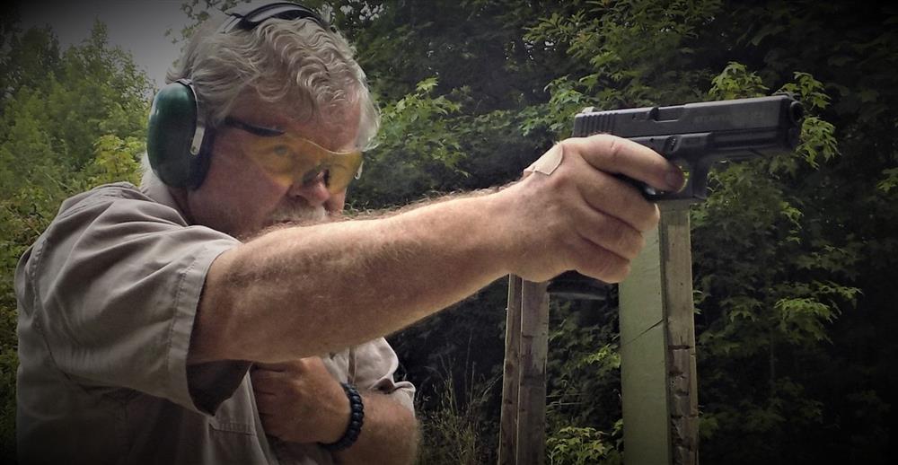 Bob Campbell shooting a pistol one handed