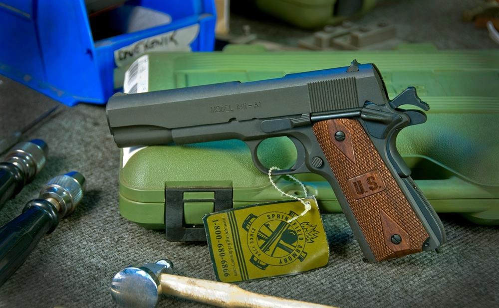 Springfield Armory 1911 pistol resting on a plastic case, left profile