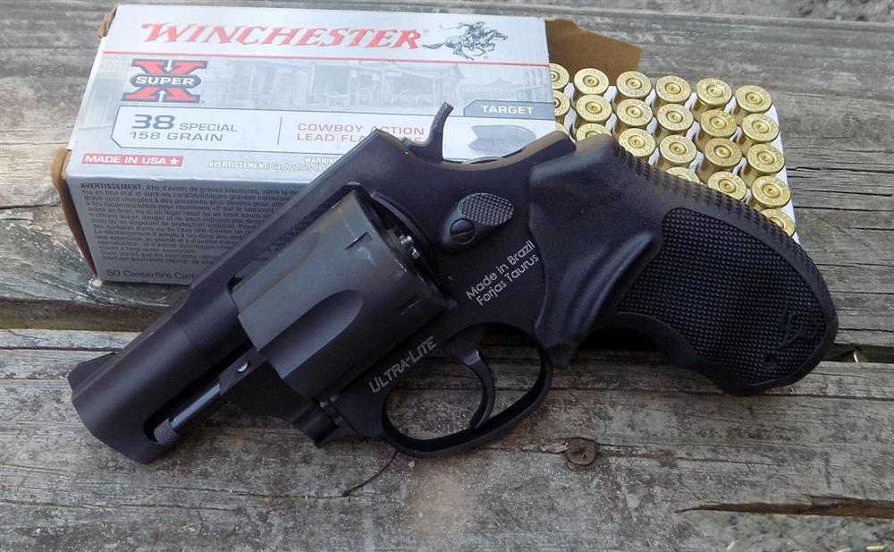 Taurus revolver propped against an open boc of Winchester white box ammunition