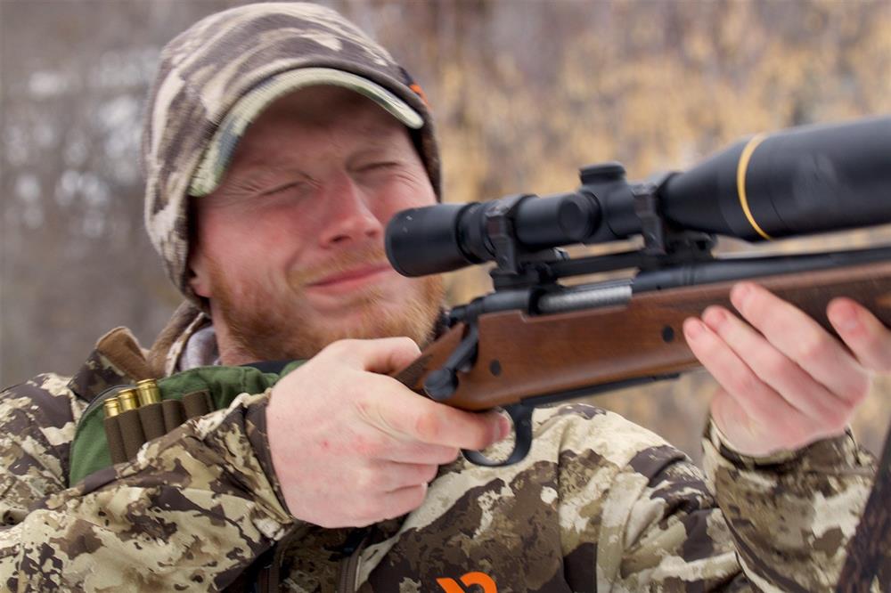 Man flinching while shooting a rifle