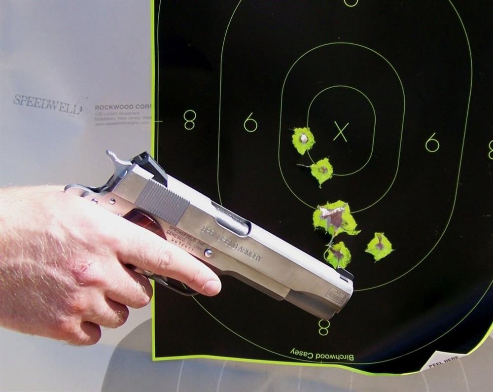 Handgun with bullet holes in the target